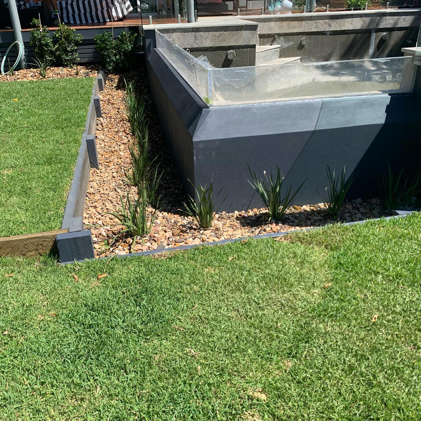 Pool surround with pebble garden edging and fresh turf in Auchenflower